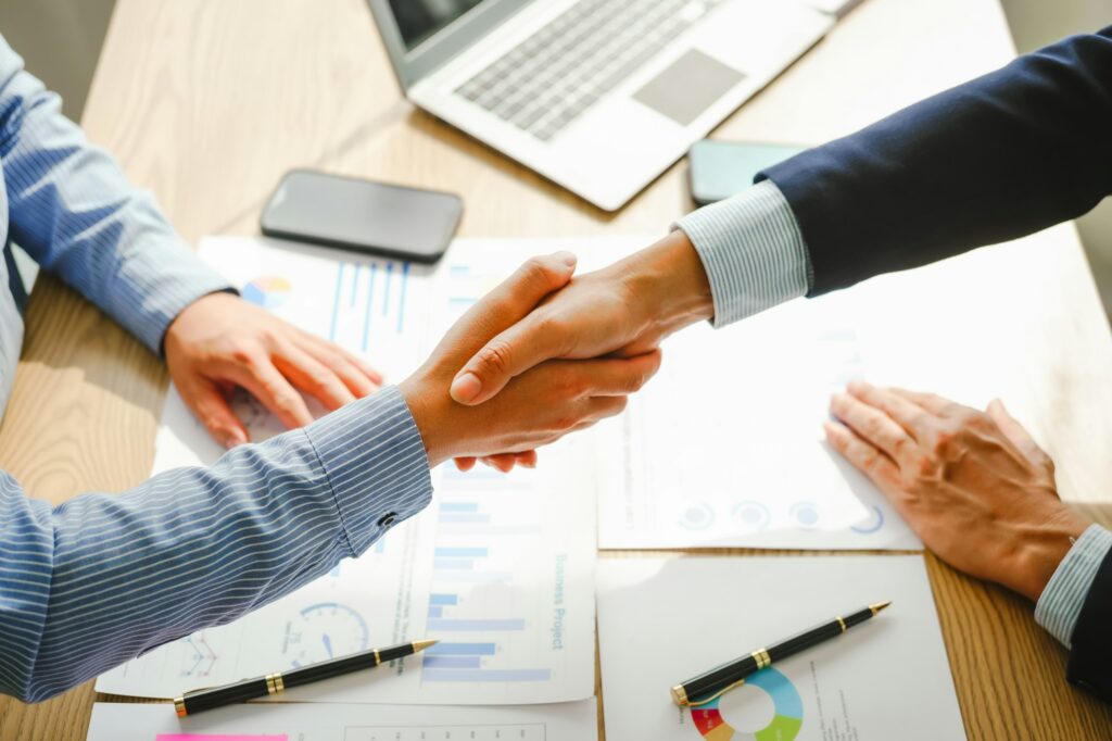 Businessman conducts financial discussions, sealing deals with handshakes. Expert in accounts, loans